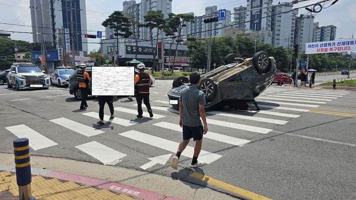 [서산=뉴시스] 14일 오전 11시39분께 충남 서산시 동문1동 서동사거리에서 차 대 차 교통사고가 나 이중 한 대가 전복된 가운데 현장에 출동한 소방대원이 인명 구조에 나서고 있다. (사진=독자 제공) 2025.07.14. photo@newsis.com *재판매 및 DB 금지
