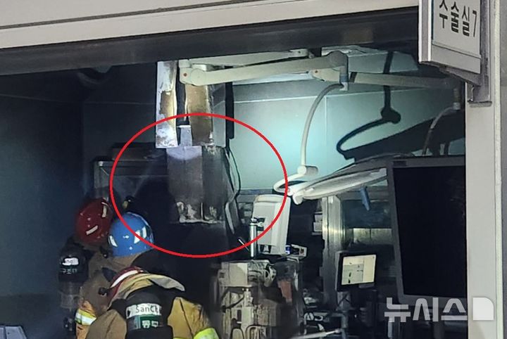 [광주=뉴시스] 14일 오전 8시12분께 광주 동구 조선대학교병원 신관 수술병동 3층 7번방에서 불이 나 소방 당국이 화재 진압을 위해 출동하고 있다. 소방 대원들의 머리 위로 불이 시작된 것으로 추정되는 콘센트(빨간 원)가 보이고 있다. (사진 = 독자 제공) 2025.07.14. photo@newsis.com