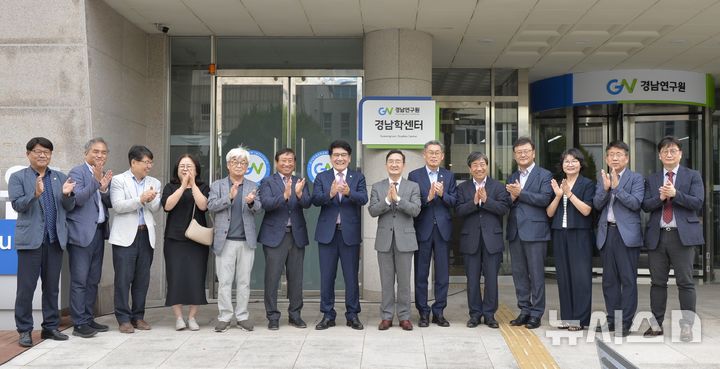 [창원=뉴시스]14일 경남연구원 경남학센터 비전 선포식에 참석한 주요 인사들이 1층 정문 앞에서 경남학센터 현판을 제막한 후 기념촬영하고 있다.(사진=경남연구원 제공) 0225.07.14. photo@newsis.com