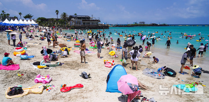 [제주=뉴시스] 우장호 기자 = 비구름대가 소강상태를 보인 14일 제주시 조천읍 함덕해수욕장에서 피서객들이 바닷물에 몸을 담그며 더위를 식히고 있다. 2025.07.14. woo1223@newsis.com