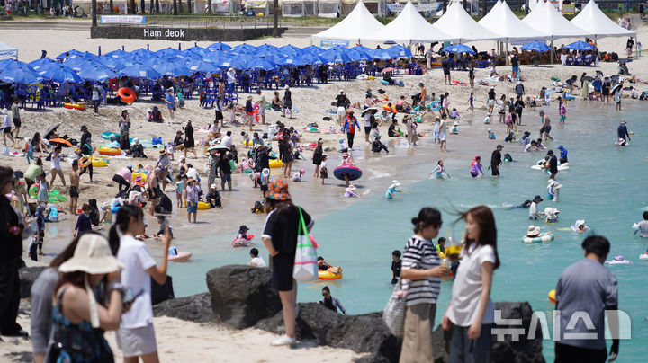 [제주=뉴시스] 우장호 기자 = 비구름대가 소강상태를 보인 14일 제주시 조천읍 함덕해수욕장에서 피서객들이 바닷물에 몸을 담그며 더위를 식히고 있다. 2025.07.14. woo1223@newsis.com
