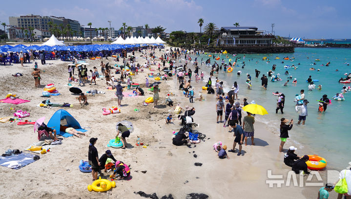 [제주=뉴시스] 우장호 기자 = 14일 제주시 조천읍 함덕해수욕장에서 피서객들이 바닷물에 몸을 담그며 더위를 식히고 있다. 2025.07.14. woo1223@newsis.com