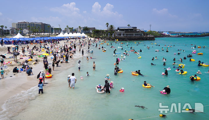 [제주=뉴시스] 우장호 기자 = 비구름대가 소강상태를 보인 14일 제주시 조천읍 함덕해수욕장에서 피서객들이 바닷물에 몸을 담그며 더위를 식히고 있다. 2025.07.14. woo1223@newsis.com