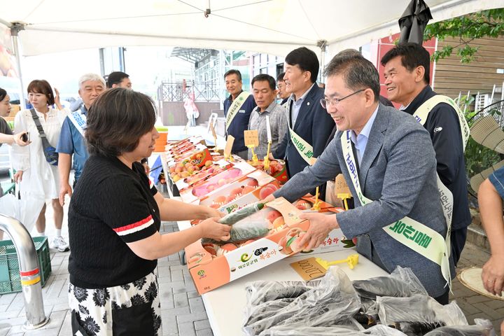 [군위=뉴시스] 김진열 군위군수가 15일 중앙고속도로 군위휴게소 으뜸농산물 판매 부스에서 농산물을 홍보하고 있다. (사진=군위군 제공) 2025.07.15. photo@newsis.com *재판매 및 DB 금지