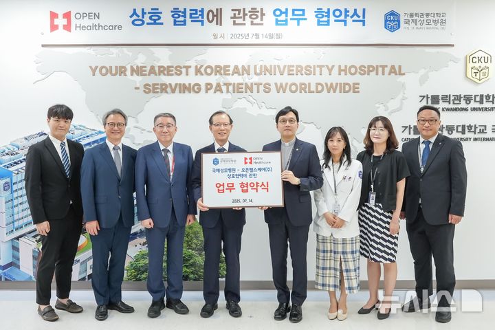[인천=뉴시스] 이민철 오픈헬스케어 대표이사(왼쪽 네번째부터)와 국제성모병원장 고동현 신부 등 관계자들이 업무협약식에서 기념 촬영하고 있다. (사진=국제성모병원 제공) 2025.07.15. photo@newsis.com