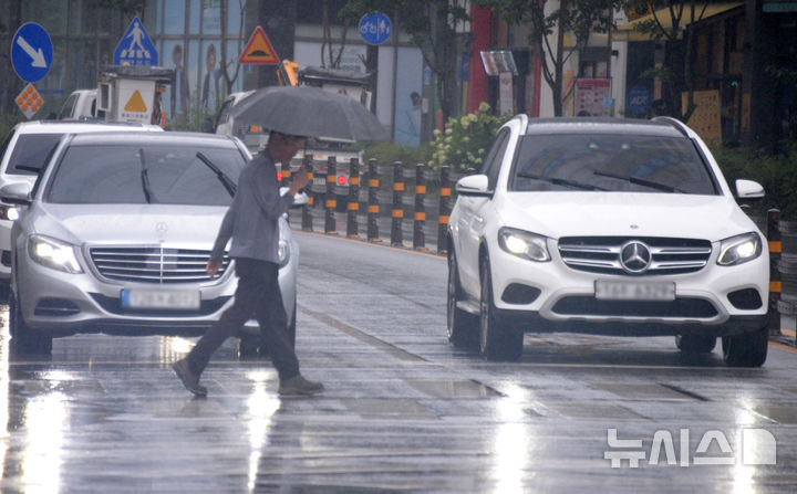[전주=뉴시스] 김얼 기자 = 전북 전주시 세병로에서 한 시민이 우산으로 비를 피하며 길을 지나고 있다. 2025.07.15. pmkeul@newsis.com