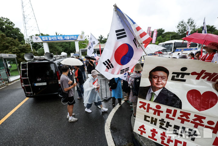 [의왕=뉴시스] 조성우 기자 = 내란 특검 소환에 불응한 윤석열 전 대통령에 대한 강제 구인 절차에 돌입한 15일 오후 경기 의왕시 서울구치소 앞에서 윤 전 대통령 지지자들이 태극기와 성조기를 들고 있다. 2025.07.15. xconfind@newsis.com