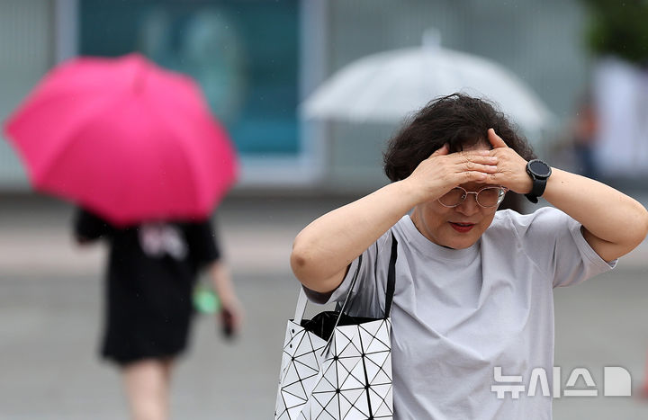 [대구=뉴시스] 이무열 기자 = 비가 내린 15일 대구 동구 동대구역 광장에서 우산을 준비하지 못한 한 시민이 손으로 머리를 가린 채 이동하고 있다. 2025.07.15. lmy@newsis.com