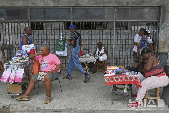 [하바나=AP/뉴시스] 15일(현지 시간) 쿠바 하바나의 한 국영 시설 입구에서 노점상들이 물건을 팔고 있다. 2025.07.16.
