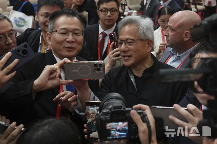 [베이징=AP/뉴시스] 젠슨 황 엔비디아 최고경영자(CEO)가 16일(현지 시간) 중국 베이징에서 열린 제3회 중국 국제 공급망 촉진 박람회 개막식에서 참석자들로부터 셀카 요청을 받고 있다. 2025.07.16.