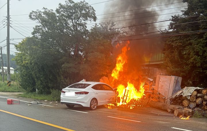 [서산=뉴시스] 16일 오전 5시55분께 충남 서산시 운산면 갈산리의 한 도로를 달리던 승용차가 주택 마당에 쌓인 잡동사니 등을 들이받고 불이 나고 있다. (사진=독자 제공) 2025.07.16. photo@newsis.com *재판매 및 DB 금지
