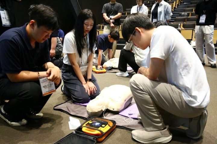 [서울=뉴시스] 한화 건설부문 안전보건관리자들이 지난 15일 상황별 스마트 응급처치 교육에 참여해 자동심장충격기(AED)를 사용해 실습하는 모습. 2025.07.16. (사진=한화 건설부문 제공) photo@newsis.com *재판매 및 DB 금지