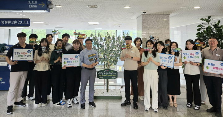 [창원=뉴시스] 강경국 기자 = 정현섭 경남 창원시 진해구청장이 16일 구청 행정동 2층에 자리한 사계절 꽃피는 청렴트리를 여름 테마로 새롭게 단장한 후 직원들과 함께 기념촬영을 하고 있다. (사진=창원시청 제공). 2025.07.16. photo@newsis.com *재판매 및 DB 금지