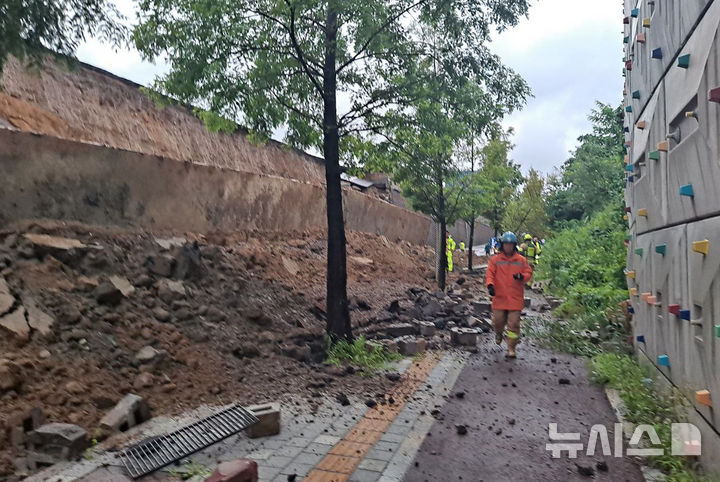 [오산=뉴시스] 김종택 기자 = 수도권 등 중부지역에 호우주의보가 발효된 16일 경기 오산시 가장교차로 옹벽이 도로로 무너져 차량을 덮치는 사고가 발생해 소방 당국이 대응 1단계를 발령, 구조작업을 벌이고 있다. (사진=경기도소방재난본부 제공) 2025.07.16. photo@newsis.com