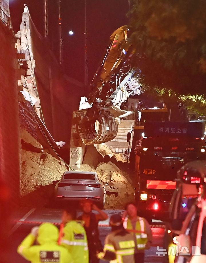 [오산=뉴시스] 김종택 기자 = 수도권 등 중부지역에 호우주의보가 발효된 16일 오후 경기 오산시 가장교차로 고가도로 옹벽이 무너져 소방관들이 매몰된 차량을 구조작업하고 있다. 2025.07.16. jtk@newsis.com