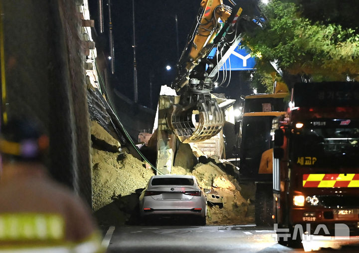 [오산=뉴시스] 김종택 기자 = 수도권 등 중부지역에 호우주의보가 발효된 16일 오후 경기 오산시 가장교차로 고가도로 옹벽이 무너져 소방관들이 매몰된 차량을 구조작업하고 있다. 2025.07.16. jtk@newsis.com