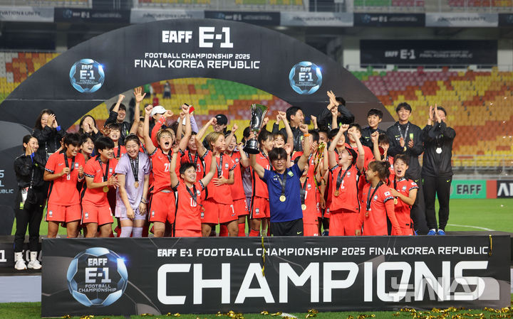 [수원=뉴시스] 김선웅 기자 = 지난 7월16일 경기 수원시 수원월드컵경기장에서 열린 2025 동아시아축구연맹(EAFF) E-1 챔피언십(동아시안컵) 여자부 시상식에서 우승국 대한민국 대표팀 신상우 감독과 선수들이 트로피를 들고 기뻐하고 있다. 2025.07.16. mangusta@newsis.com