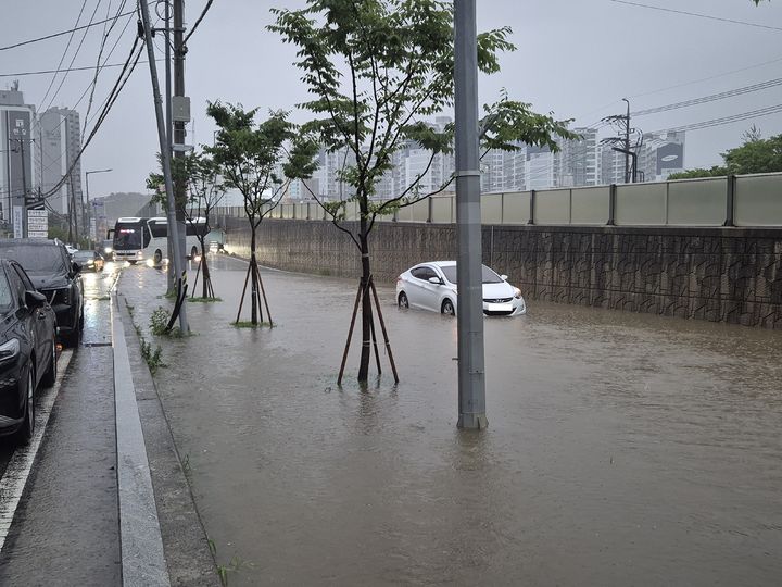 [당진=뉴시스] 김덕진 기자=17일 오전 호우로 침수된 충남 당진시 탑동사거리 주변 도로를 아반떼 차량이 지나가고 있다. (사진=당진시 제공) 2025.07.17. photo@newsis.com *재판매 및 DB 금지