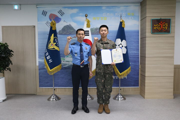 [동해=뉴시스] 동해해경 김환경 서장이 좌주한 어선을 조기에 발견·신고한 공으로 육군 제23경비여단 4대대 소속 정호준 중사에게 표창장을 수여한 후 기념사진을 찍고 있다.(사진=동해해경 제공)photo@newsis.com *재판매 및 DB 금지