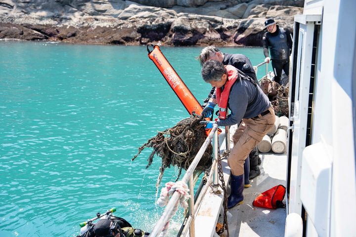 17일 전남 여수시 돌산 진목방파제 연안에서 수중 정화 작업을 위해 전문 스쿠버가 바다 속에서 수거한 폐그물을 끌어올리고 있다.(사진=롯데쇼핑 제공) *재판매 및 DB 금지