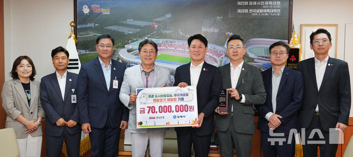 [김해=뉴시스]BNK경남은행 김태한 은행장(오른쪽서 네 번째)이 17일 김해시청에서 홍태용 시장으로부터 감사패를 받고 있다. 경남은행은 김해 주촌면 무지개공원 내 맨발걷기 체험장을 조성해 기부했다.(사진=BNK경남은행 제공) 2025.07.17. photo@newsis.com