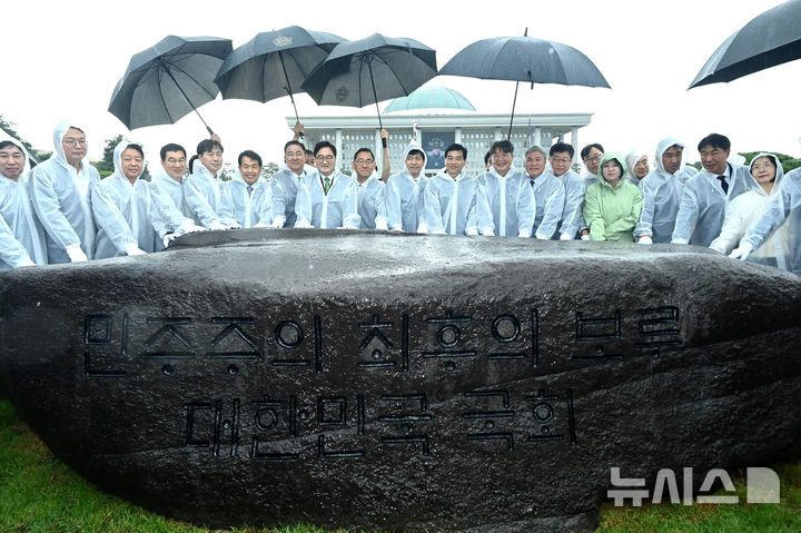 [서울=뉴시스] 국회사진기자단 = 17일 오전 서울 여의도 국회 잔디광장에서 열린 국회 상징석 제막식에서 우원식(왼쪽 여덟번째) 국회의장 등 참석자들이 기념촬영을 하고 있다. 상징석에는 국회가 민주주의의 보루로서 ‘12·3 비상계엄’ 해제를 이끌었다는 내용의 문구가 새겨져 있다. 2025.07.17. photo@newsis.com