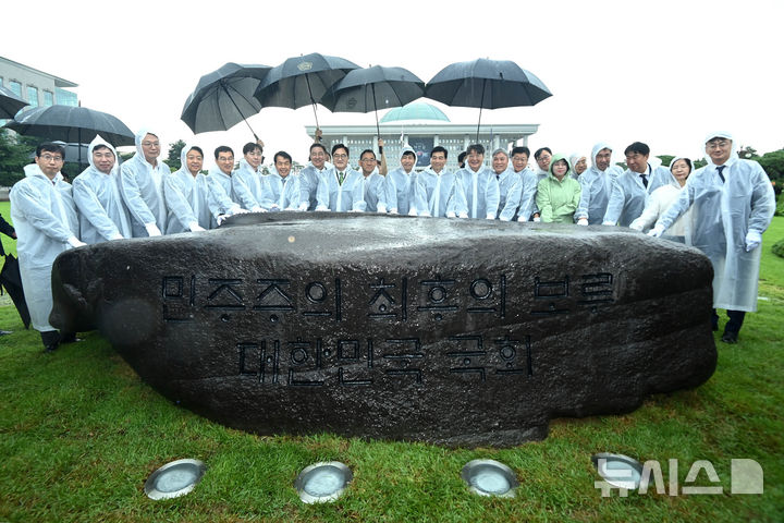 [서울=뉴시스] 국회사진기자단 = 17일 오전 서울 여의도 국회 잔디광장에서 열린 국회 상징석 제막식에서 우원식(왼쪽 아홉번째) 국회의장 등 참석자들이 기념촬영을 하고 있다. 상징석에는 국회가 민주주의의 보루로서 ‘12·3 비상계엄’ 해제를 이끌었다는 내용의 문구가 새겨져 있다. 2025.07.17. photo@newsis.com
