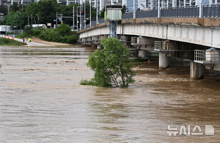 [평택=뉴시스] 김종택 기자 = 경기 남부와 충청지역에 호우경보가 발효된 17일 경기 평택시 안성천 군문교 인근 노을생태문화공원 산책로가 흙탕물에 잠겨 있다. 2025.07.17. jtk@newsis.com