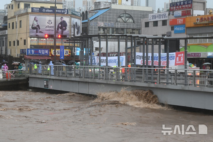 [광주=뉴시스] 박기웅 기자 = 17일 오후 광주 서구 양동복개상가 인근 태평교 밑으로 흐르는 광주천 강물이 범람 수위까지 도달하고 있다. 이날 태평교는 범람 우려로 주민 대피령이 내려졌다. 2025.07.17. pboxer@newsis.com