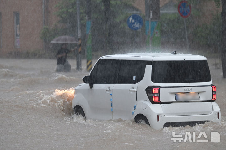 [광주=뉴시스] 이영주 기자 = 광주지역에 하루 최고 311㎜ 폭우가 쏟아진 17일 오후 침수된 광주 북구청 앞 도로 위로 한 차량이 지나가고 있다. 2025.07.17. leeyj2578@newsis.com
