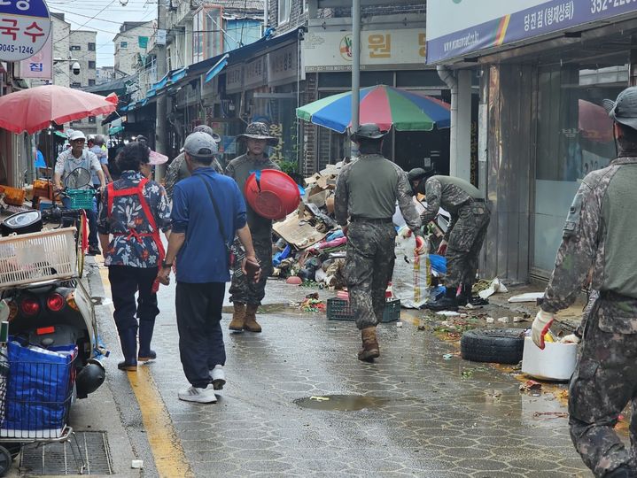 [당진=뉴시스] 김덕진 기자=18일 오전 충남 당진전통시장에 폭우 피해 복구를 위해 지원나온 군인들이 쓰레기를 치우고 있다. 2025.07.18. spark@newsis.com *재판매 및 DB 금지