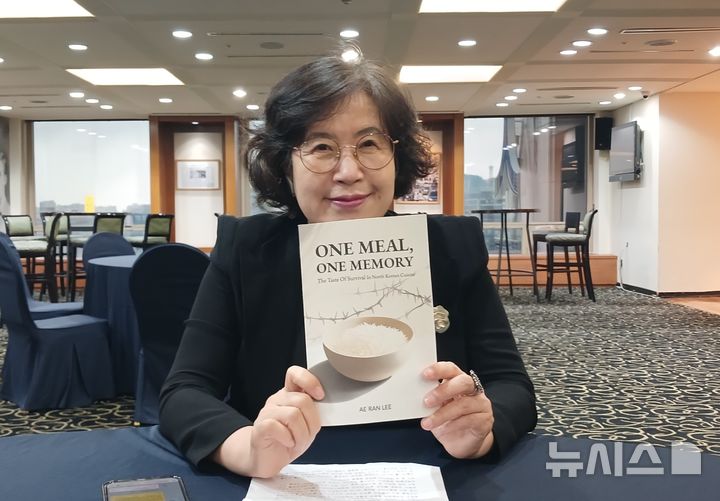 [서울=뉴시스]탈북 여성 1호 박사로 알려진 이애란 박사가 17일 자신의 영문 신간 'ONE MEAL, ONE MEMORY - The Taste of Survival in North Korean Cuisine(한 끼 한 기억, 북한 요리 속 생존의 맛)'에 대해 소개했다. 이 박사가 자신의 신간을 들고 보여주는 모습. (사진=독자제공) 2025.07.18