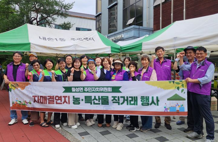 [괴산=뉴시스] 18일 칠성면 주민자치위원회가 자매결연지인 의왕시 내손1동을 방문해 대학찰옥수수 직거래 행사를 연 뒤 기념사진을 찍고 있다. (사진=괴산군 제공) 2025.7.18. photo@newsis.com *재판매 및 DB 금지