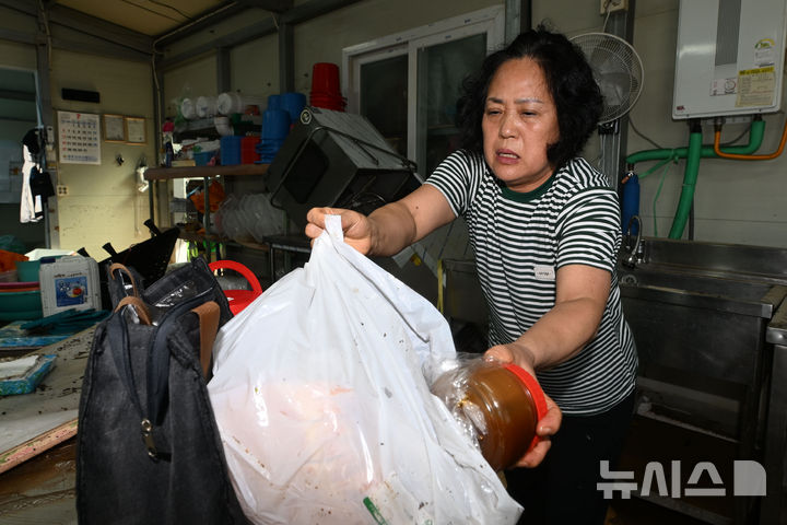 [광주=뉴시스] 이영주 기자 = 18일 오전 광주 북구 신안동에서 침수피해를 입은 주민이 창고에서 물건을 건져내고 있다. 광주에는 전날 하루 동안 426.4㎜의 비가 내리면서 1939년 기상관측 이후 광주지역 역대 최고 일강수량을 기록했다. 2025.07.18. leeyj2578@newsis.com