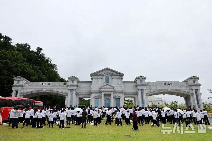 [가평=뉴시스] 배훈식 기자 = 김건희 여사 의혹을 수사하는 민중기 특별검사팀이 통일교 압수수색에 들어간 18일 오후 경기 가평군 천원궁 앞에서 통일교 외국인 신자들이 기도를 하고 있다. 2025.07.18. dahora83@newsis.com