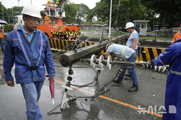 [케손=AP/뉴시스] 19일(현지 시간) 필리핀 케손시에서 관계자들이 제6호 태풍 위파 영향으로 무너진 전신주를 복구하고 있다. 2025.07.22.