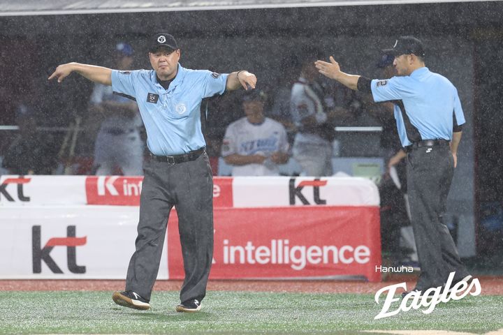 [서울=뉴시스] 19일 수원KT위즈파크에서 열린 프로야구 한화 이글스와 KT 위즈의 2025 신한 쏠뱅크 KBO리그 경기 6회 심판진이 우천 중단을 선언하고 있다. (사진=한화 이글스 제공) 2025.07.19.