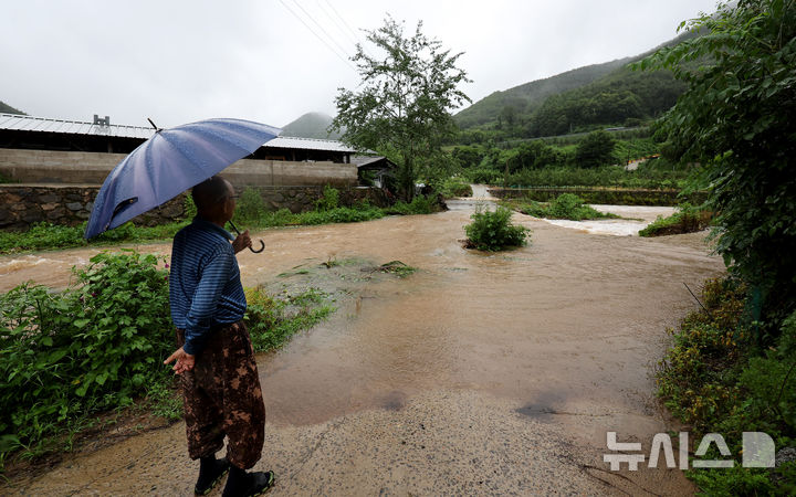 [대구=뉴시스] 이무열 기자 = 사진은 호우특보가 내렸던 지난 19일 대구 군위군 학암리 인근에서 한 어르신이 물에 잠긴 보행로를 바라보고 있는 모습. 2025.07.19. lmy@newsis.com