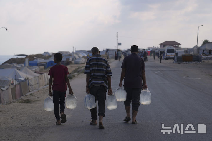 [AP/뉴시스] 가자 중부 데이르 알발라서 플라스틱 통에 물을 배급 받아가고 있는 주민들 