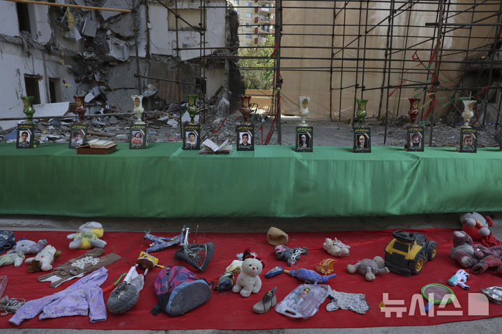 [테헤란=AP/뉴시스]지난 6월13일 이스라엘의 이란 수도 테헤란 거주 지역 공습으로 숨진 어린이들의 사진이 전시돼 있다. 앞에는 어린이들의 인형과 책가방 등  유품들이 놓여 있다.  2025.08.03.