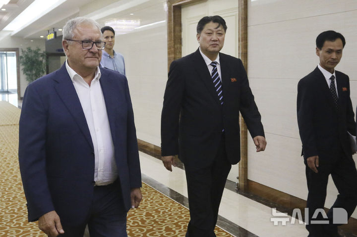 Pak Chon Jong, center, North Korea's vice-minister of Physical Culture and Sports, walks with Riccardo Fraccari, left, president of the World Baseball Softball Confederation (WBSC), as he greets him and his delegation upon their arrival at the Pyongyang International Airport in Pyongyang, North Korea, Saturday, July 19, 2025. (AP Photo/Jon Chol Jin)