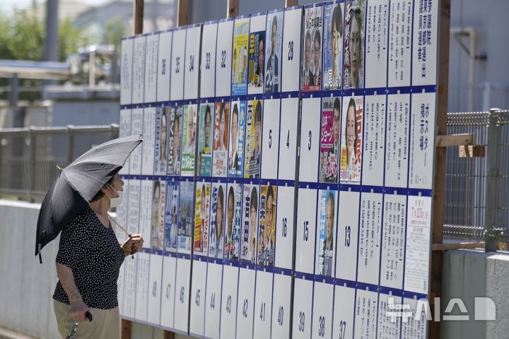 [도쿄=AP/뉴시스] 지난 20일 일본 도쿄의 한 투표소 인근에서 한 유권자가 참의원 선거 게시판을 보고 있다. 선거에선 정권 비판 성향의 신흥 정당의 약진이 눈에 띄었다. 2025.07.21.