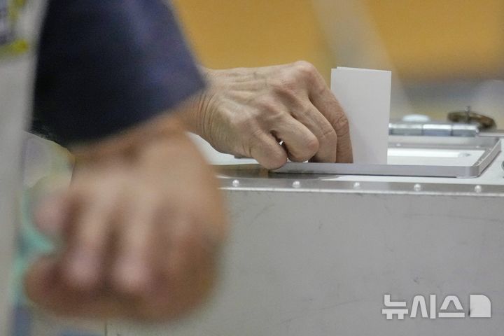 [도쿄=AP/뉴시스] 지난 20일 일본 도쿄 한 투표소에서 한 유권자가 투표함에 투표용지를 넣고 있다. 2025.07.21.