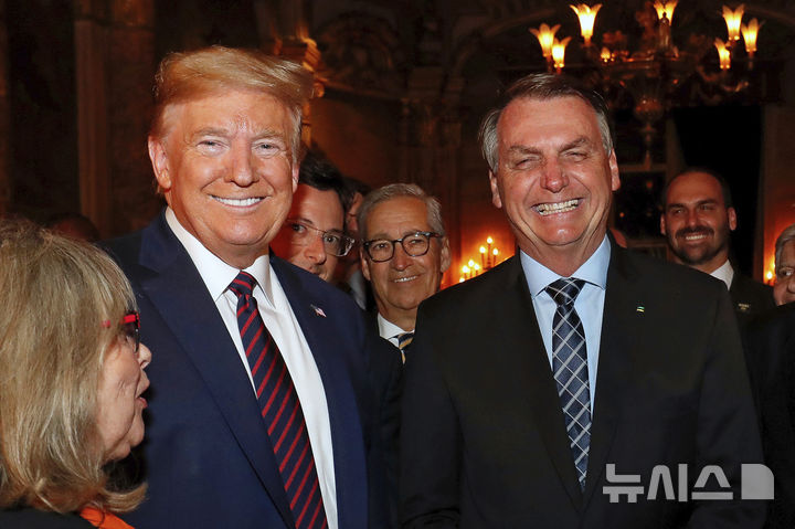 [팜비치=AP/뉴시스] 도널드 트럼프 미국 대통령과 자이르 보우소나루 전 브라질 대통령이 지난 2020년 3월 7일(현지 시간) 미국 플로리다주 팜비치 마라라고에서 만찬을 하며 기념촬영 하고 있다. 오른쪽은 보우소나루 아들 에두아르도. 2025.07.22.