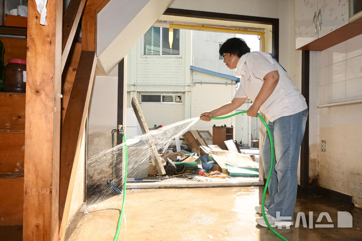 [광주=뉴시스] 이영주 기자 = 20일 오전 광주 북구 신안동 서암대로 100번길 주변 한 주택에서 자원봉사자가 물청소하고 있다. 광주·전남에는 지난 사흘간 500~600㎜ 괴물 폭우가 쏟아졌다. 2025.07.20. leeyj2578@newsis.com