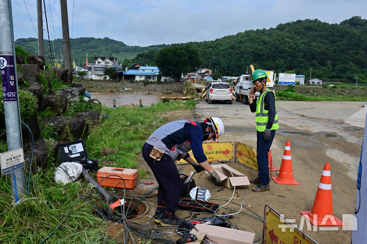 [산청=뉴시스] 차용현 기자 = 20일 오전 경남 산청군 문대마을 인근 문대교가 지난 19일 내린 폭우로 붕괴되면서 통신선이 끊어지자 KT관계자들이 복구 작업을 펼치고 있다.2025.07.20.con@newsis.com