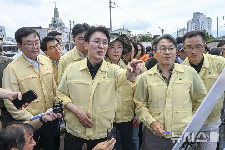 [광주=뉴시스] 이영주 기자 = 김민석 국무총리가 20일 집중호우로 침수피해를 입은 광주 북구 신안교 현장을 찾아 피해 현황을 보고받고 있다. 김 총리는 관계자들과 함께 침수 원인과 향후 복구 계획에 대해 논의하며, 주민 불편 최소화를 위한 대책 마련을 주문했다. 2025.07.20. leeyj2578@newsis.com