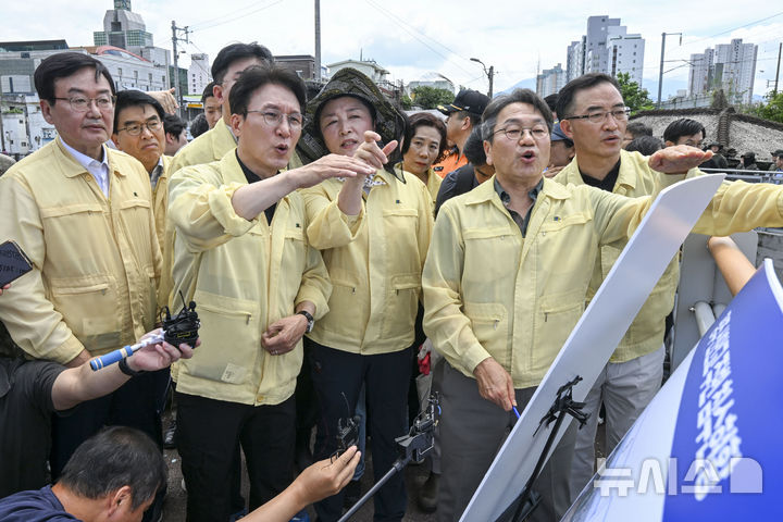 [광주=뉴시스] 이영주 기자 = 김민석 국무총리가 20일 집중호우로 침수피해를 입은 광주 북구 신안교 현장을 찾아 피해 현황을 보고받고 있다. 김 총리는 관계자들과 함께 침수 원인과 향후 복구 계획에 대해 논의하며, 주민 불편 최소화를 위한 대책 마련을 주문했다. 2025.07.20. leeyj2578@newsis.com