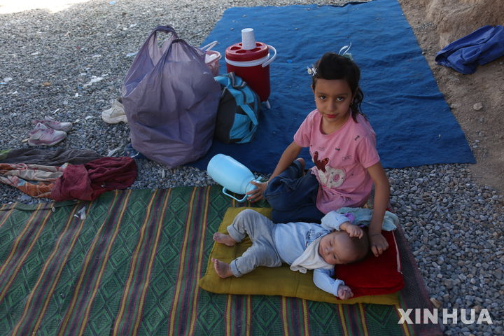 [ 카불=신화/뉴시스] 아프가니스탄의 수도 카불에서 7월 19일 1500명이 넘는 이란과 파키스탄의 아프간 난민이 귀국하면서 20일 어린이 두 명이 아직 머물 숙소가 없어 임시 천막 앞 바닥 위에 앉아 있다. 