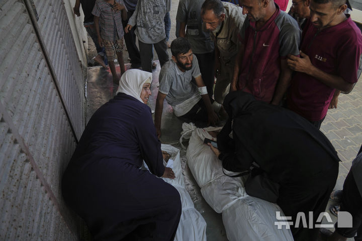 [AP/뉴시스] 21일 가자 중남부 데이르 알발라에서 이스라엘군 공습에 사망한 주민들과 그 가족들